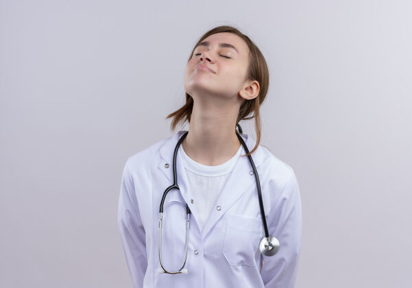 医疗穿着医用长袍和听诊器的宁静年轻女医生抬起头 闭上眼睛 留有复印空间空间复制关闭