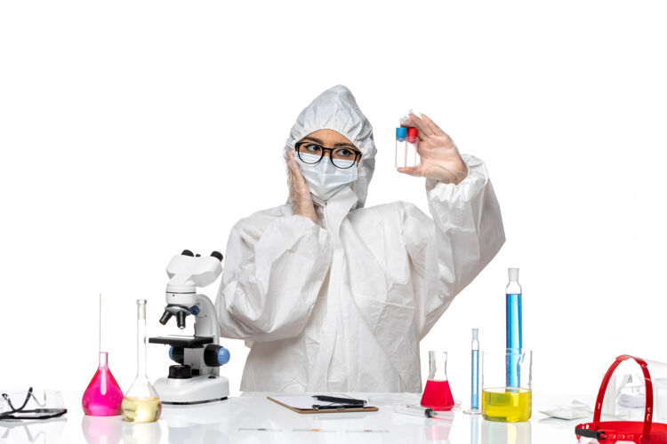 健康前视图穿着特殊防护服的女化学家拿着白色背景上的空烧瓶健康病毒共价化学保护烧瓶空