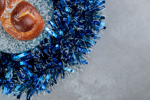 圣诞节蓝色的银色圆圈 中间有一个髻在大理石桌子上圣诞节 甜点 小吃 烘焙 糕点 节日 美味 金箔 小面包 美味 精致 美味 辛辣 美味