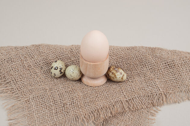 膳食鸡蛋杯中的鸡蛋和麻布上的鹌鹑蛋贝壳鹌鹑食品