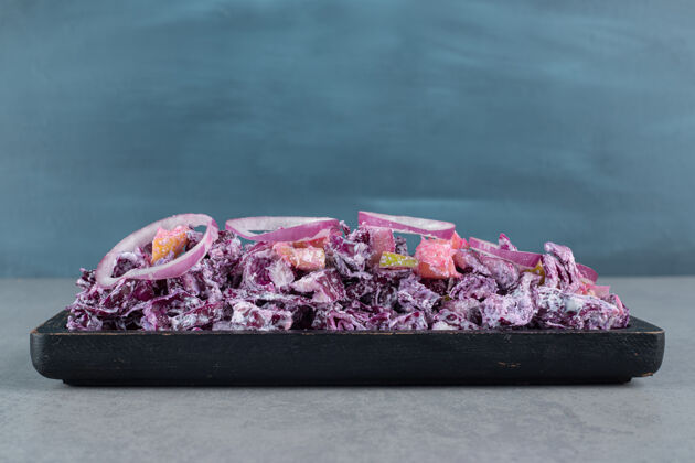 正餐切碎的紫洋葱和卷心菜沙拉放在水泥桌上的盘子里午餐美味晚餐