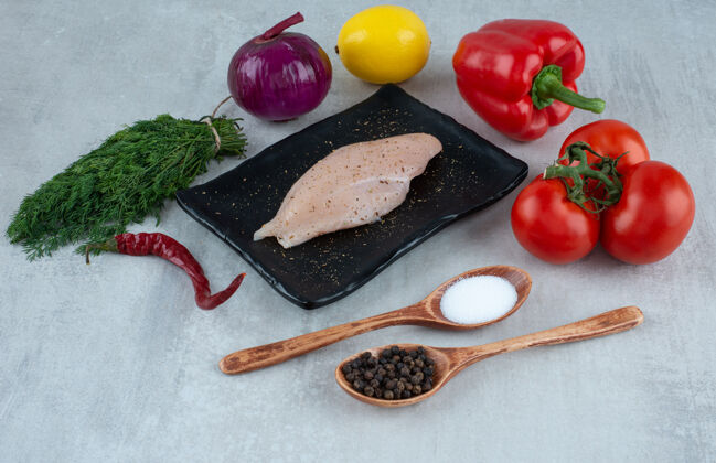 胡椒鸡胸 调味品和各种蔬菜在灰色的表面上青菜鱼片盐