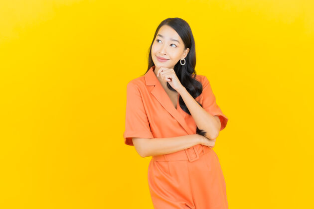 橙色连身裤肖像美丽的亚洲年轻女子微笑着行动黄色年轻漂亮明亮