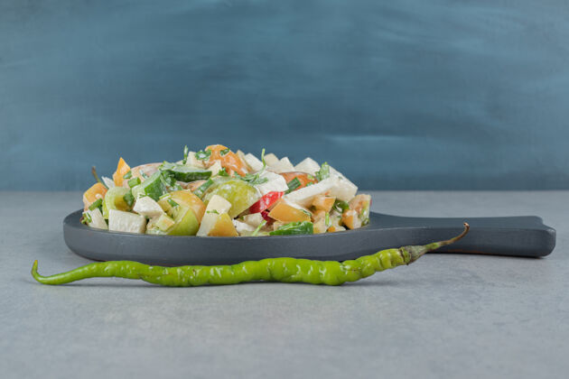 晚餐切碎的蔬菜和水果沙拉放在木板上餐具晚餐香料