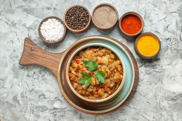 一餐顶视图烤茄子沙拉碗和不同的香料碗在灰色的表面食物料理胡椒粉