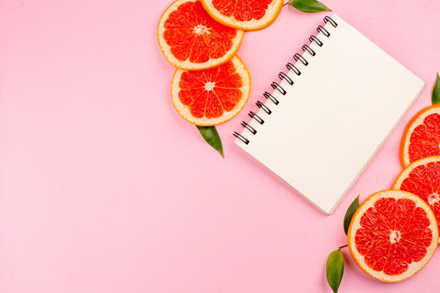 信封美味的葡萄柚与粉红色表面上的记事本俯视图记事本柑橘庆典