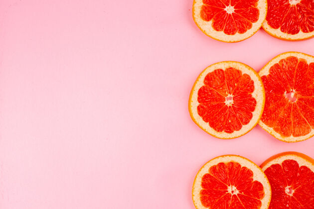 饮食浅粉色表面上美味的葡萄柚切片多汁水果俯视图健康柑橘果汁