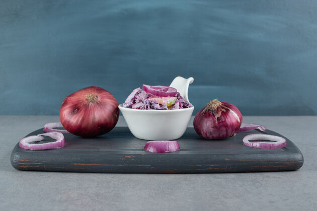 混凝土切碎的紫洋葱和卷心菜沙拉放在陶瓷杯里午餐颜色石头