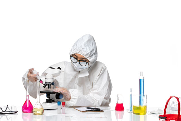 医学前视图身着特殊防护服的女化学家在白色背景的covid化学病毒实验室中处理溶液和注射液套装白人专业