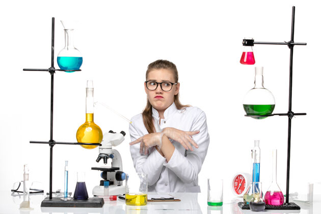 化学前视图穿着医疗服的女化学家坐在白色背景上 用溶液冲洗化学冠状病毒实验室医生坐