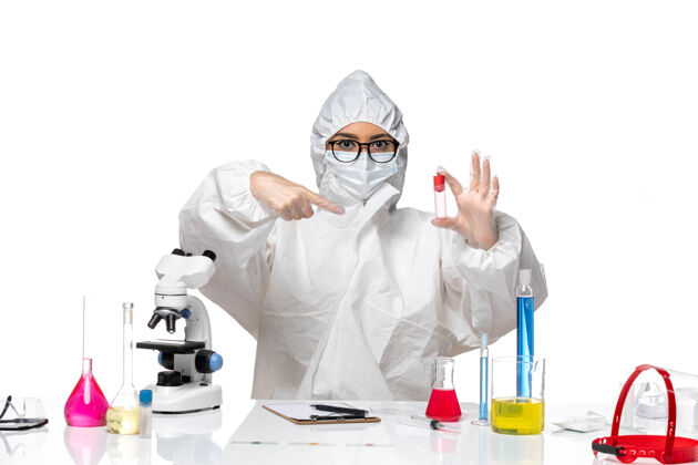 视图正面图身着特殊防护服的女化学家拿着烧瓶在白色背景上病毒健康化学冠状病毒-实验室实验室外套诊所