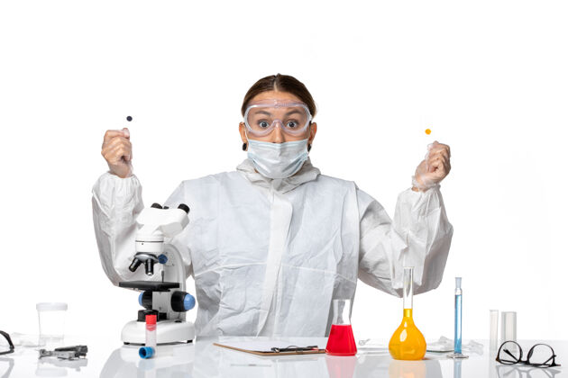 药品正面图女医生穿着防护服 戴着口罩 拿着白色背景的样本医学健康大流行病毒冠状病毒实验室外套套装视图