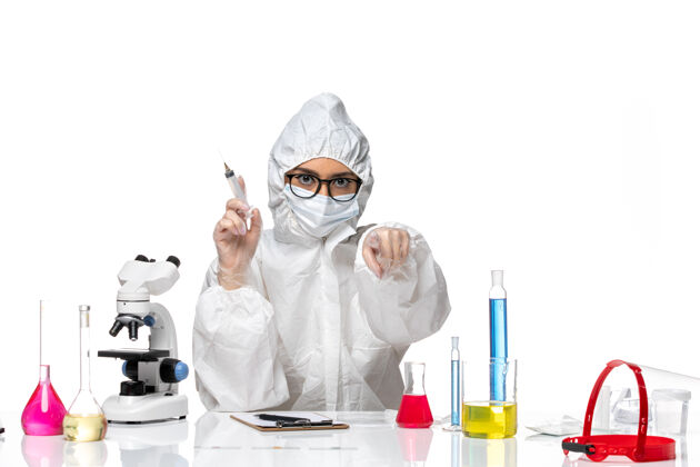 面罩前视图穿着特殊防护服的女化学家手持白色背景化学冠状病毒大流行的注射剂白色医生医院