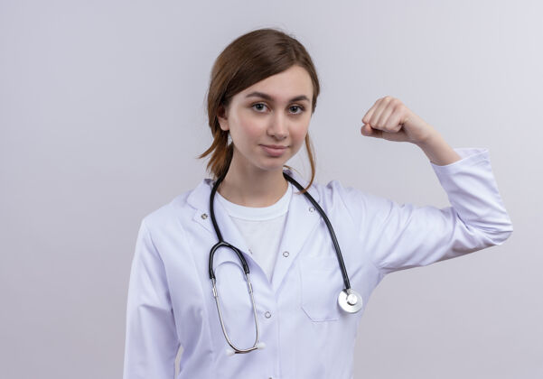 强壮自信的年轻女医生穿着医用长袍和听诊器做着坚强的手势医生长袍女性