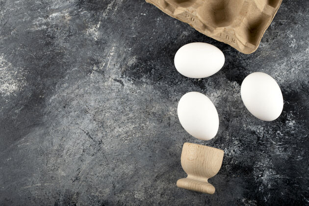 早餐一个木制的鸡蛋杯 里面有煮熟的鸡蛋膳食贝壳木材