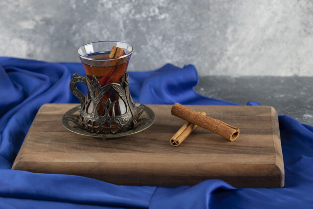 热的一杯肉桂茶放在木砧板上木头芳香马克杯