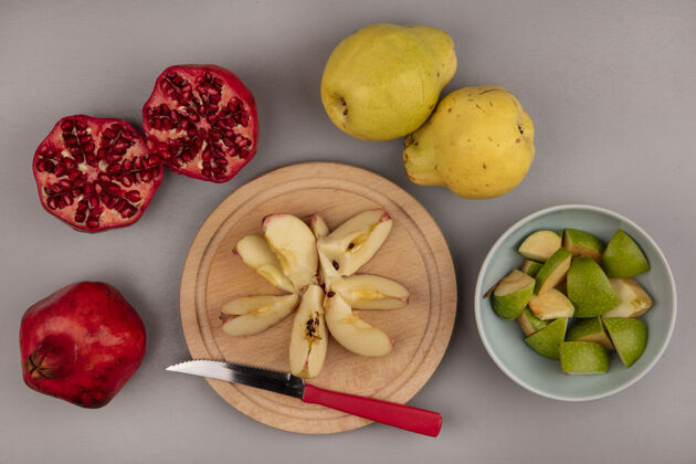 刀顶视图新鲜切碎的苹果片在一个木制的厨房板与石榴和木瓜隔离刀食物切片灰