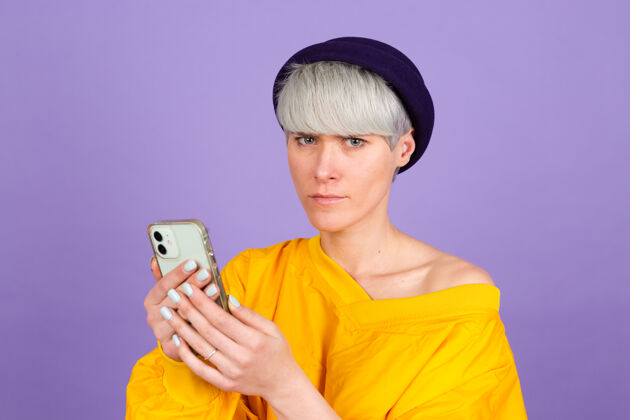 不开心紫色墙上的时髦欧洲女人聊天电话手机