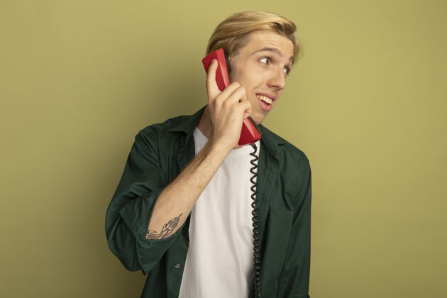 人高兴地看着身边穿着绿色t恤的金发小伙子在电话里讲话说话壁板男人