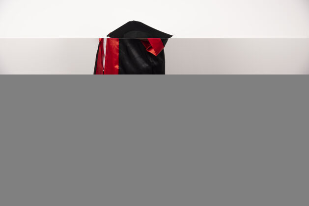 长袍年轻的研究生穿着制服拿着白色的毕业证书年轻立场成功