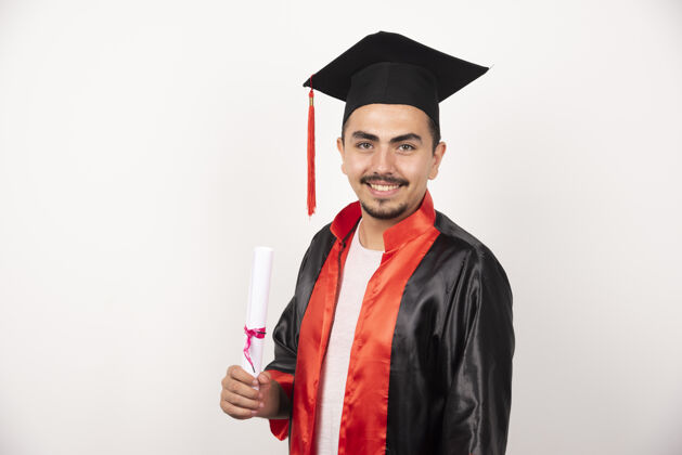 学生快乐的男生拿着毕业证书在白色上摆姿势成功教育成就