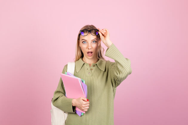 青少年粉色墙上穿着休闲毛衣的漂亮欧洲女人立场高考试