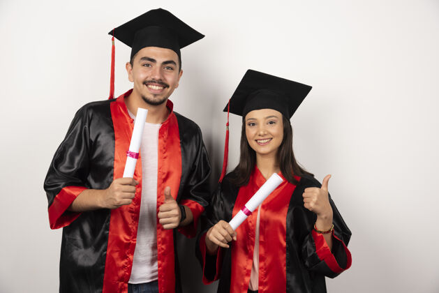 学士有文凭的应届毕业生对白人竖起大拇指学生学历帽子