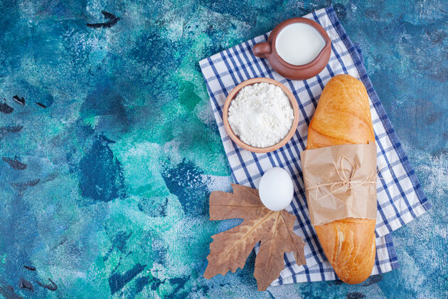 烘焙面包 面粉 鸡蛋和牛奶放在茶巾上 蓝色背景面粉酵母美味
