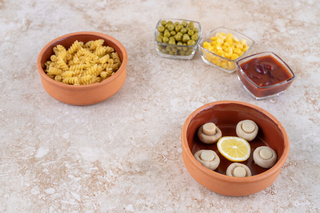 青豆一碗煮熟的糊状物和大理石表面的各种配料风味烹饪切片