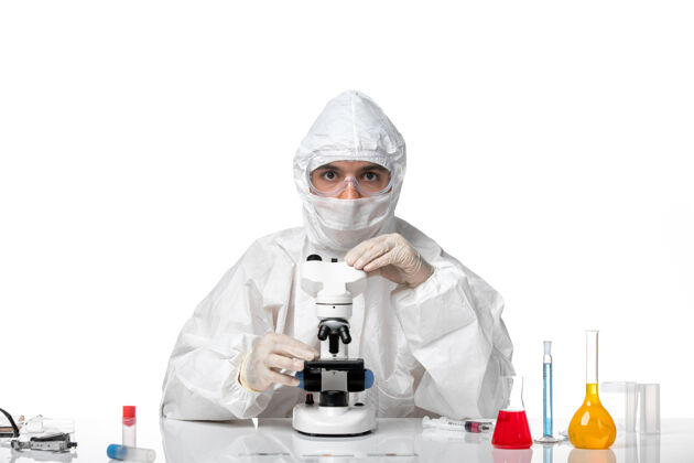 使用正面图：男医生穿着防护服 戴着面罩 在空白处用显微镜观察病毒实验室外套男医生