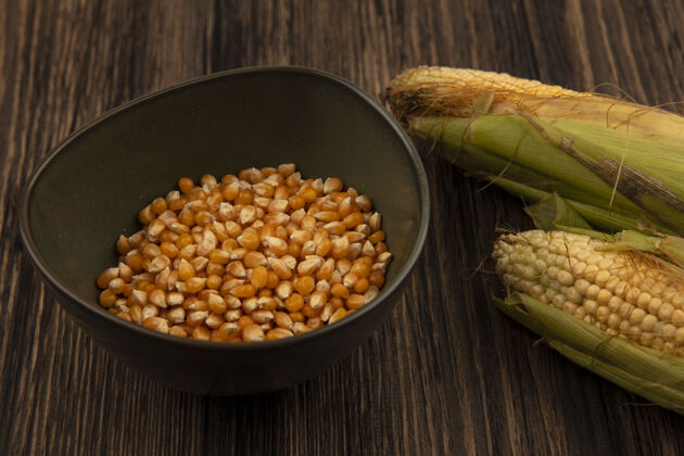 食物顶视图新鲜玉米与头发与玉米粒在一个木桌碗新鲜碗顶部