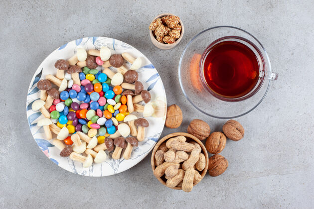 牙粉一杯茶旁边的各种糖果和坚果大理石背景高品质的照片水果营养核桃