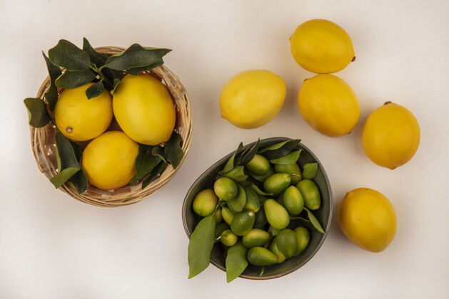 皮肤顶视图绿色皮肤的金冈人在一个碗与柠檬桶上的白色背景柠檬绿色金盏花