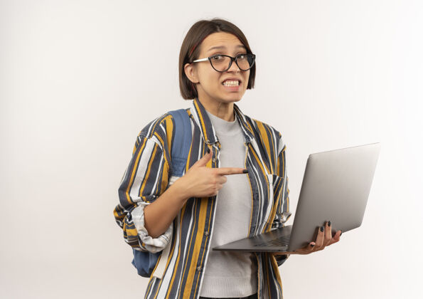笔记本电脑印象深刻的年轻女学生戴着眼镜 背着包拿着笔记本电脑 指着白色的隔离年轻印象拿着