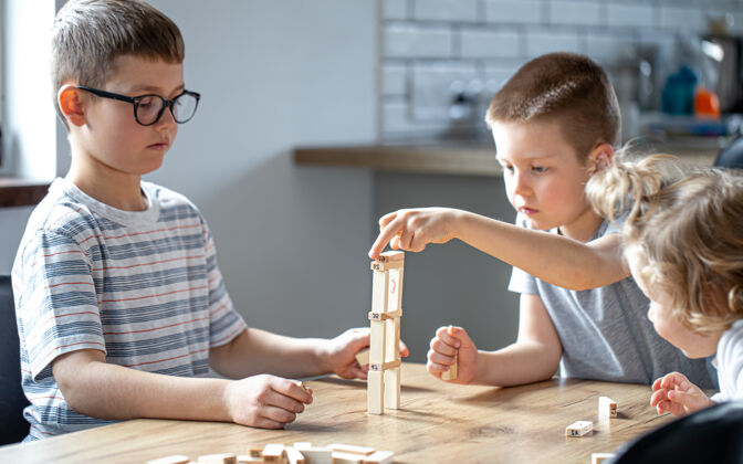 房子小孩子在家里的厨房里用木块玩棋盘游戏休闲桌子小