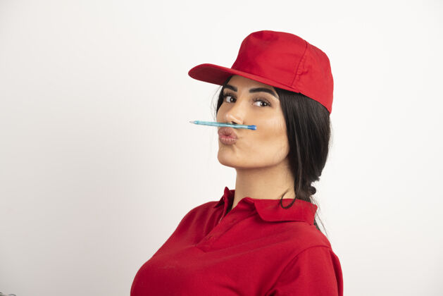 工人穿着红色制服的女信使 嘴里叼着钢笔高质量的照片女性黑发钢笔