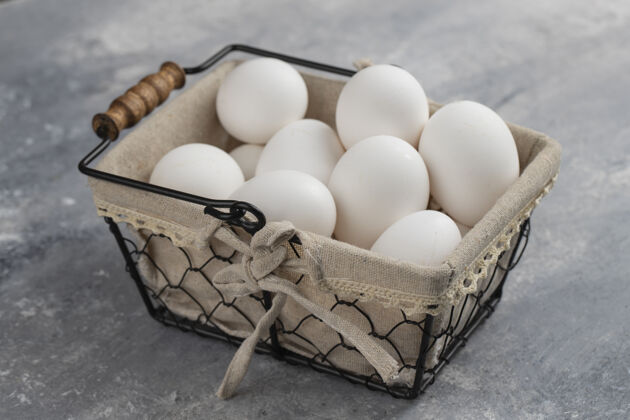 碗装满新鲜鸡蛋的篮子放在大理石上生的家禽鸟
