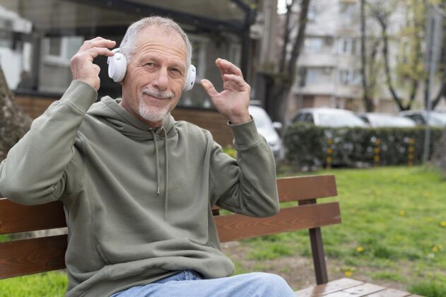 现代戴着耳机听音乐的现代老人休闲水平生活方式