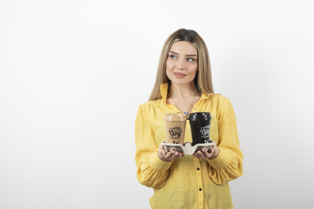 人物一张年轻女子的肖像 她拿着几杯咖啡摆姿势模特站着茶