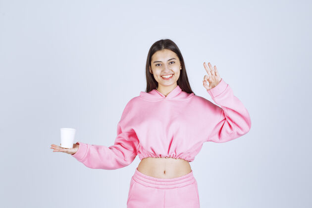 人穿着粉色睡衣的女孩捧着咖啡杯 享受着咖啡的味道女人姿势喜欢