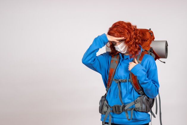肖像正面图女游客带着背包 戴着面具上山旅游女人背包累