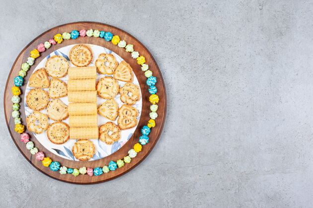 爆米花在大理石背景的木板上 用爆米花糖包着一盘各式各样的饼干高质量的照片美味各色烘焙食品