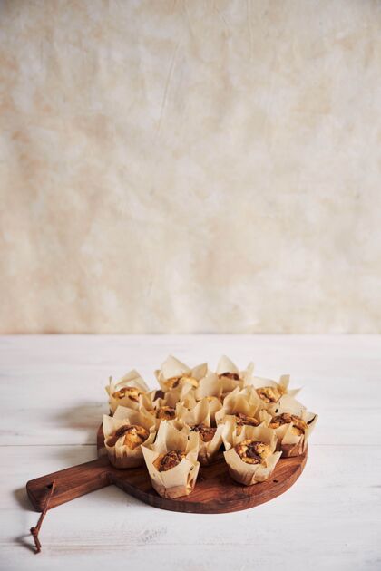 烘焙垂直高角度拍摄美味的巧克力松饼在一个白色桌子上的木盘节食美食食物