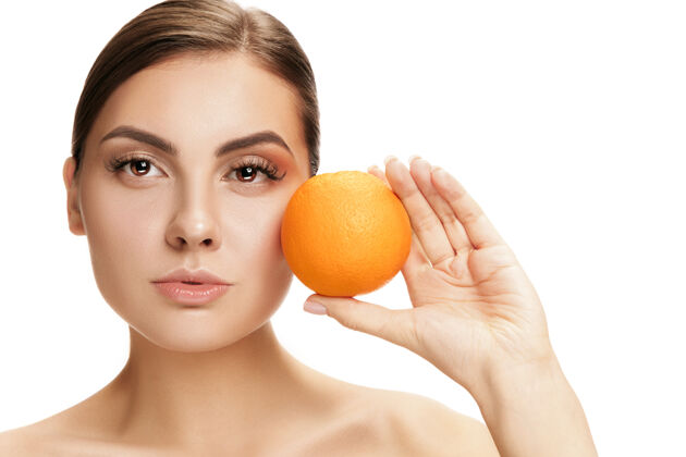 护理美丽的白种人微笑的女人的肖像被隔离在白色的墙壁上 带着橙色的水果美丽 护理 皮肤 治疗 健康 水疗 化妆品食物年轻微笑