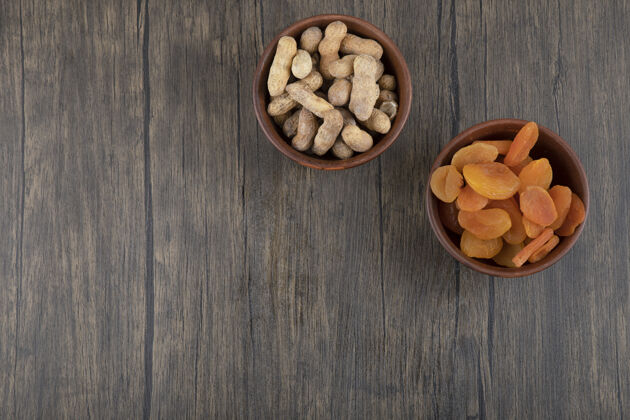 抗氧化剂一碗健康的杏干和花生放在木桌上健康甜点成熟