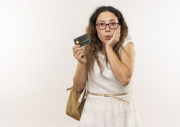 印象令人印象深刻的年轻漂亮的女学生戴着眼镜 背着信用卡 手放在脸上 隔离在白色背女学生包
