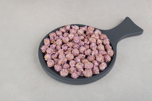 垃圾食品大理石表面有紫色爆米花的小平底锅营养玉米饮食
