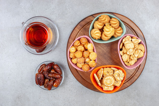 美食一杯红枣茶放在大理石背景的木板上 旁边是各式各样的饼干高质量的照片美味午餐早餐