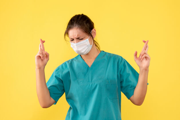 视图正面图黄色背景上穿着无菌口罩医用衬衫的女医生消毒面具正面