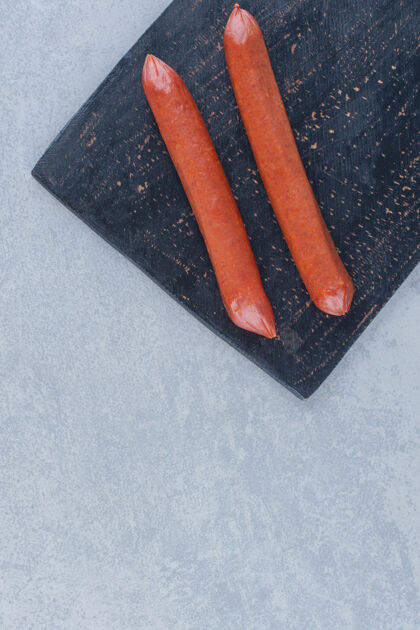 肉黑色砧板上新鲜意大利香肠叶子的特写照片干烹饪一餐